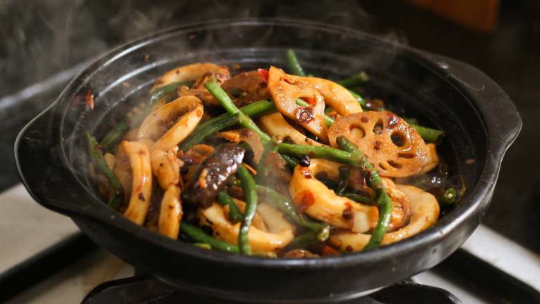 麻辣鱿鱼香锅,把所有物料倒入砂锅内,用小火慢慢收汁,略翻几下,使鱿鱼蔬菜入味,淋些许香油即可。