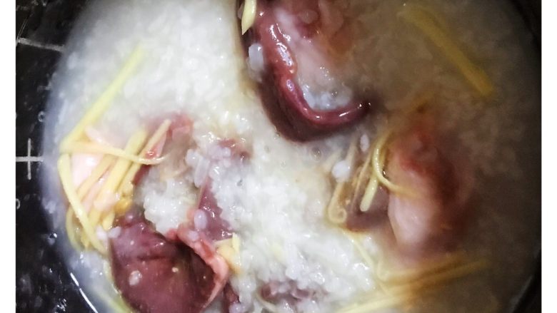 生滚猪杂粥,盛出适量的白粥另起小锅煮沸,然后把生料倒入沸腾的白粥里,一边煮一边用勺子搅拌粥。