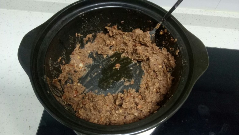 自制红豆沙,砂锅中间倒入食用油,小火炒豆沙。