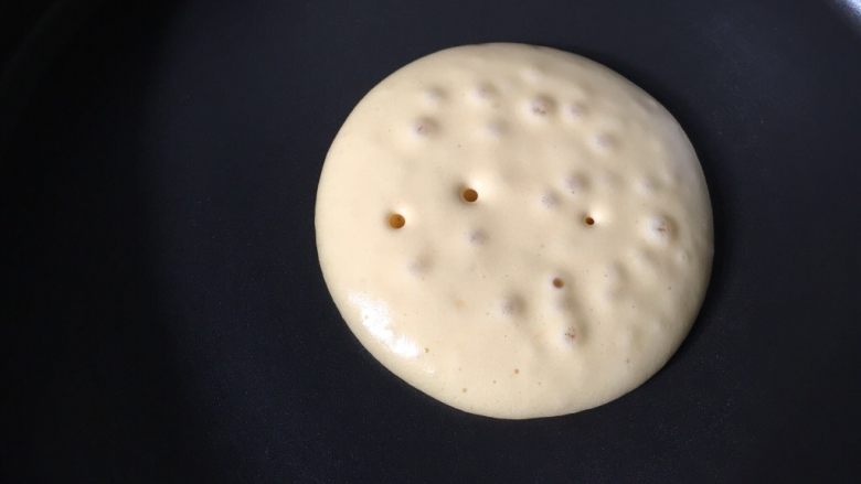 松饼,松饼坯在锅里表面开始冒大泡时,就要用硅胶锅铲快速铲起来,开始煎松饼另一面。