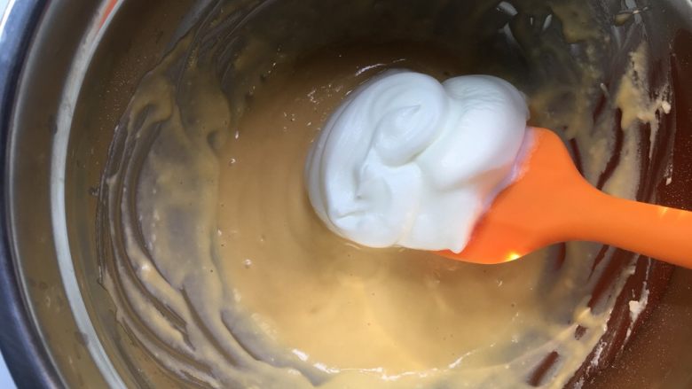 松饼,用硅胶刀铲出一半蛋白糊倒入蛋黄面糊里,以翻拌手法搅拌均匀面糊,这里动作要轻柔,切不可划圈搅拌。