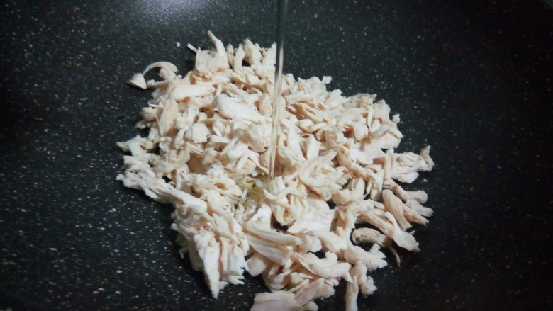 休闲小零食~鸡肉松,把鸡胸肉放不粘锅,加10克加拿大芥花油(加拿大芥花油味道清淡,拿来做肉松最合适不过,加了加拿大芥花油,做好的肉松色泽好)