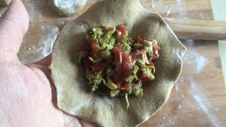 地瓜面槐花馅肉包子,放入肉馅,包起来。