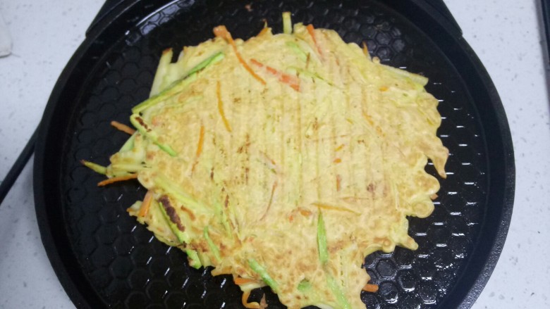 西葫芦、胡萝卜、鸡蛋饼,翻面,煎至两面金黄。