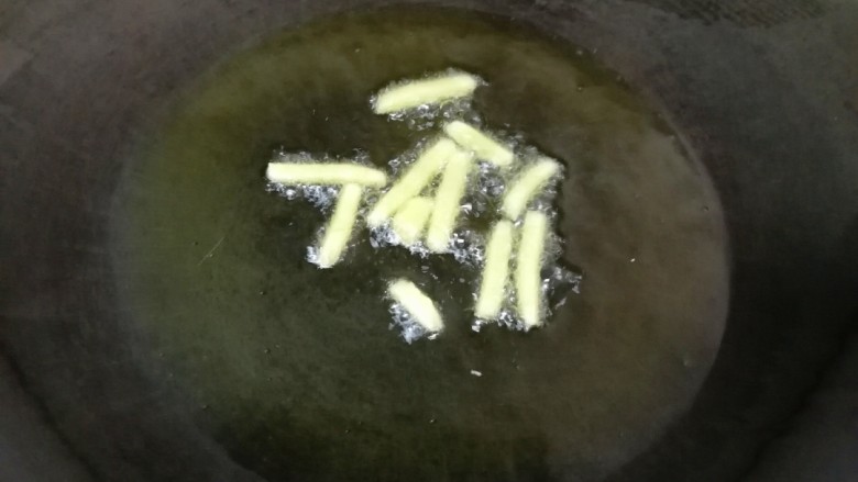 蒜苔炒牛肉, 炒锅烧热倒入适量的食用油,下入生姜炒香。