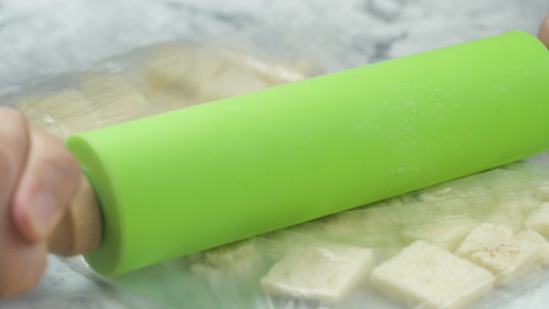 微波炉自制面包糠,冷却后,放入保鲜袋中,用擀面杖擀成粉末状
