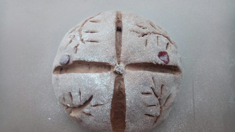 可可荞麦坚果欧包,发至2倍大。在面团上筛一层高筋面粉,再用刀片割出图案。