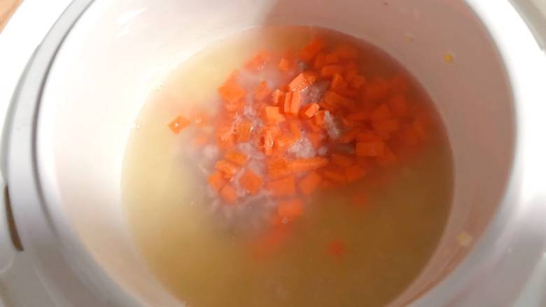 【宝宝辅食】杂蔬牛肉粥,带米粥黏稠后放入牛肉碎和胡萝卜碎,继续熬制30分钟;