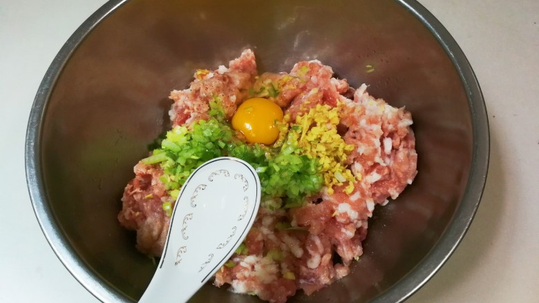 豇豆猪肉水饺,放入适量清水,三勺放一次顺时针搅拌均匀至有粘性,再三勺放一次顺时针搅拌均匀至有粘性,这样重复四五次