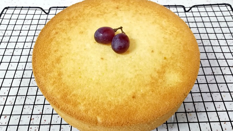 酸奶戚风蛋糕,时间到，从烤箱里取出蛋糕，垂直摔一下震出热气，倒扣在晾网上，凉透之后脱模。