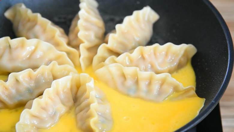 抱蛋煎饺—好看又好吃的煎饺人人爱,缓慢倒入蛋液,轻晃摇匀。