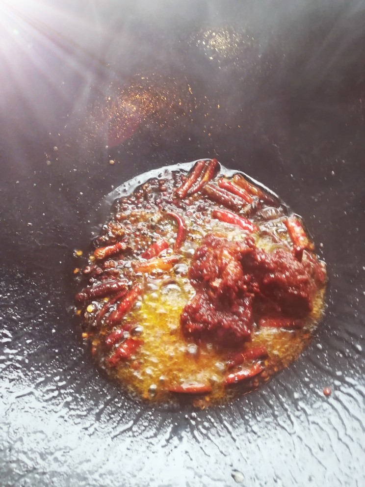 水煮肉片,锅里入油烧热 入干辣椒花椒炒香后放入豆瓣酱和酱炒香