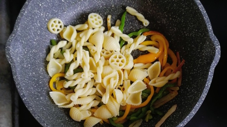 宝宝辅食—彩椒和牛咖喱炒意面,彩椒炒软后，倒入煮熟的意面翻炒均匀