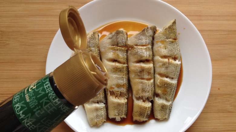 清蒸南极冰鱼,冰鱼蒸好后,将盘里的汤汁倒掉,并把姜片和葱段去掉,再倒入<a style='color:red;display:inline-block;' href='/shicai/ 864'>蒸鱼豉油</a>