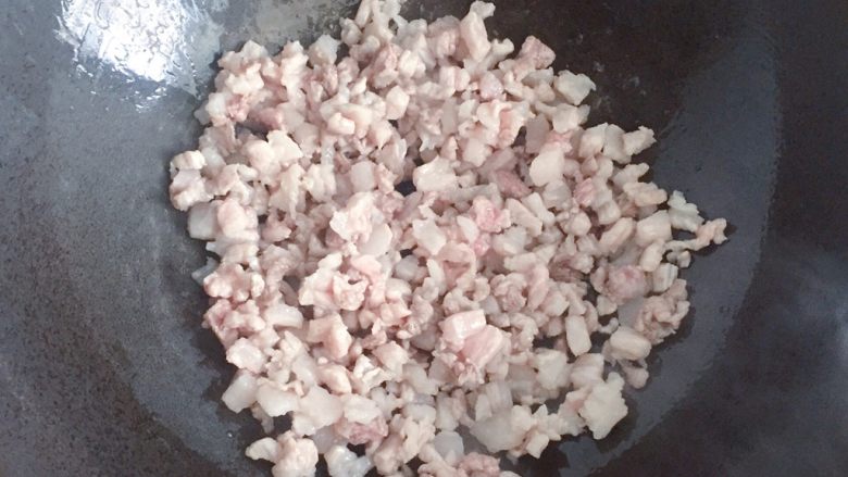 豆角饼,锅中倒入少许油烧热,下入五花肉丁炒至变色。