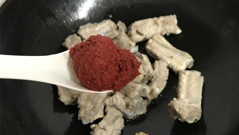 红酒糟排骨,然后加入1勺红酒糟,炒匀,让排骨沾上红酒糟。