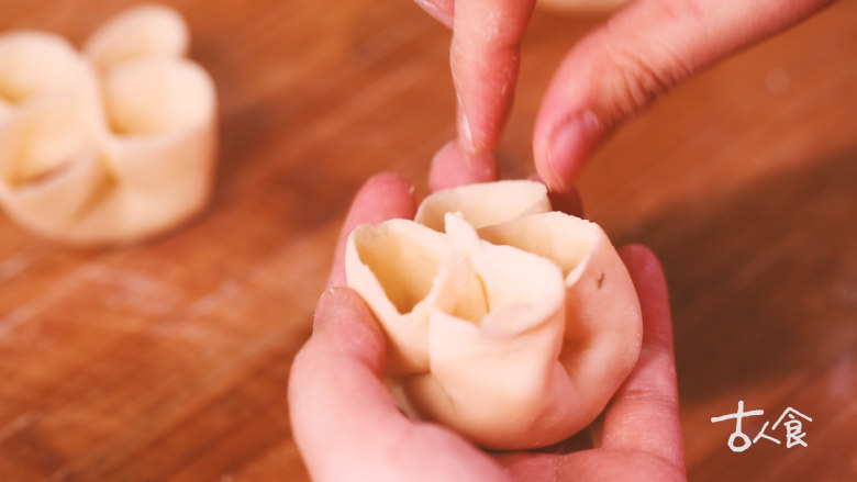 【清·四喜饺子】,用勺子(或手)将对角处撑开,依次填入四种蔬菜碎。