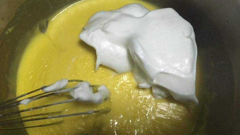 古早味蛋糕,取三分之一蛋白霜,加入到面糊中,先用蛋抽翻拌均匀,之后加入剩下的蛋白霜,一起翻拌均匀