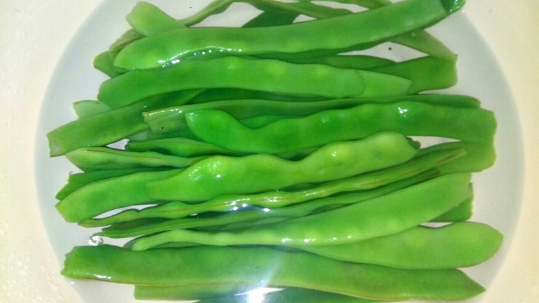 扁豆肉丝炒千张,捞出放入冷水,多换几次冷水,使扁豆完全冷却,从而保持翠绿