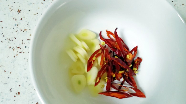 蓑衣黄瓜,蒜瓣切片,<a style='color:red;display:inline-block;' href='/shicai/ 86464'>干红辣椒</a>切丝,放在小碗里。