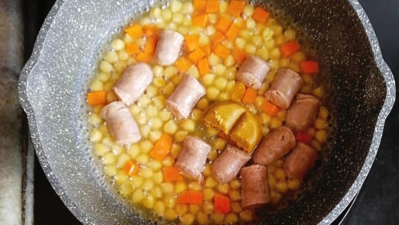 鹰嘴豆香肠咖喱意面,香肠和胡萝卜煮10分钟后,放入一块<a style='color:red;display:inline-block;' href='/shicai/ 693'>咖喱</a>块,继续中火煮