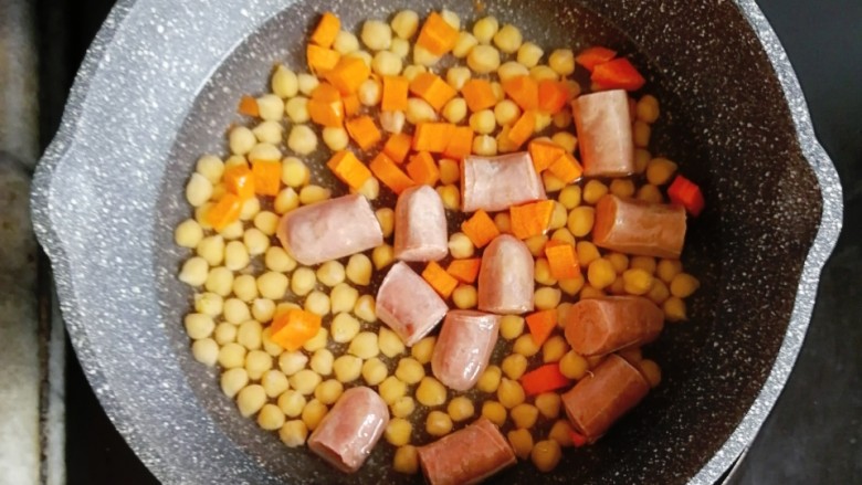 鹰嘴豆香肠咖喱意面,鹰嘴豆煮10分钟后,水倒掉,重新往锅内加400g水,煮开后,倒入香肠和<a style='color:red;display:inline-block;' href='/shicai/ 25'>胡萝卜</a>,继续中火煮10分钟