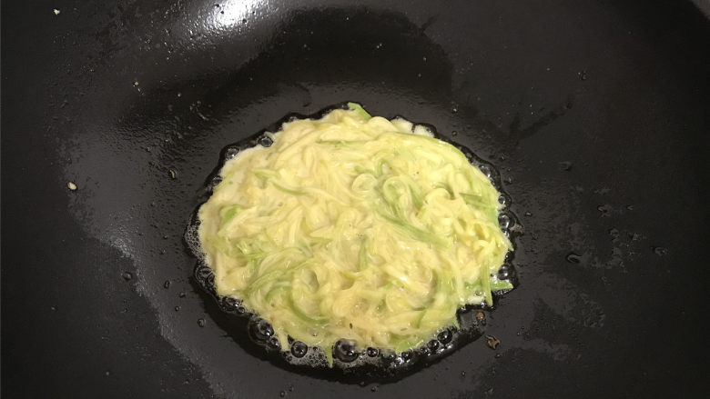 西葫芦鸡蛋饼,七成热,放入一勺面糊摊均匀。