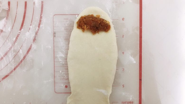 肉松小面包,松弛好的面团擀开成长条,一端按薄向两边拉一下,再放上馅,自上而下卷起,两头收口