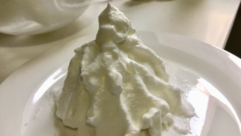 午后甜点-漂浮雪山微波炉版,找一个能进微波炉的盘子,用勺子将打发好的蛋白霜做成一座雪山的形状