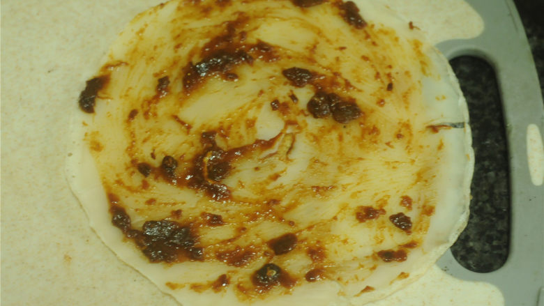 不用和面的煎饼,将饼皮放在案板上,抹上少许<a style='color:red;display:inline-block;' href='/shicai/ 712'>甜面酱</a>