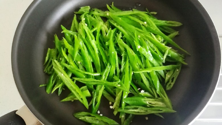 辣椒炒肉丝,锅里不要加油,干锅放入辣椒丝。