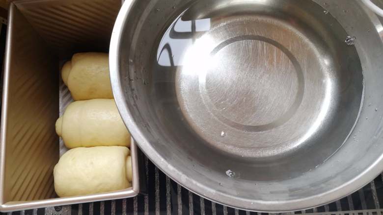 纯牛奶土司,将模具放入发酵箱里面,放入一碗热水,温度保持在38度左右。