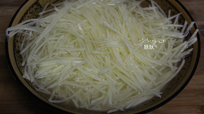 土豆丝饼,切好的土豆丝冲去淀粉,用清水浸泡十分钟。