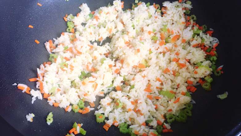 牛肉炒饭,然后将提前弄散的米饭倒入锅里,翻炒均匀并炒散。