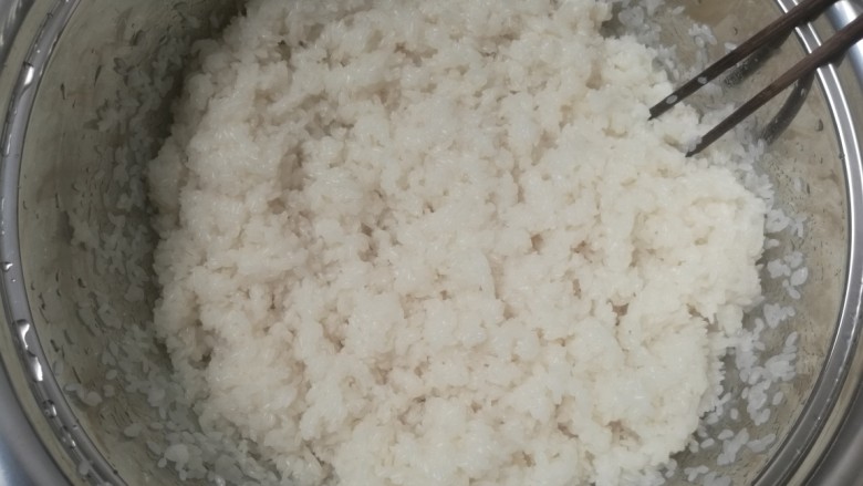 自制糯米甜酒,把凉好的糯米饭倒盆里,用约300克的凉开水把酒曲调好,然后把凉开水倒到盆里把糯米饭打散,不起团。