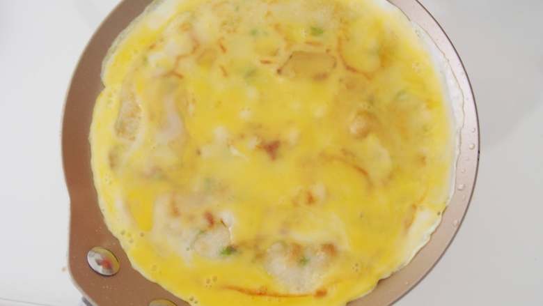 意酱鸡蛋卷饼,一面煎熟后翻面,磕上适量打散的鸡蛋