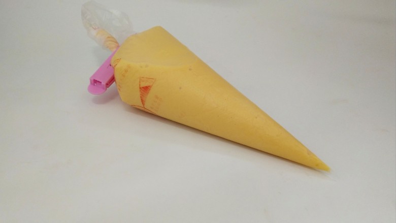 黄金鸡蛋面,再把裱花袋套在一个杯子中,将面糊倒入,用夹子把口夹紧,防止流出,将其静置15分钟