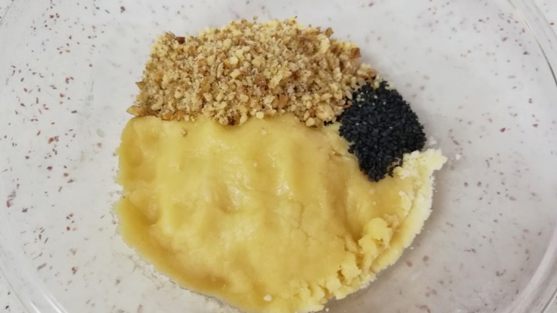华夫小酥球,带上一次性手套将面粉揉捏成团,加入碾碎的核桃仁和黑芝麻。