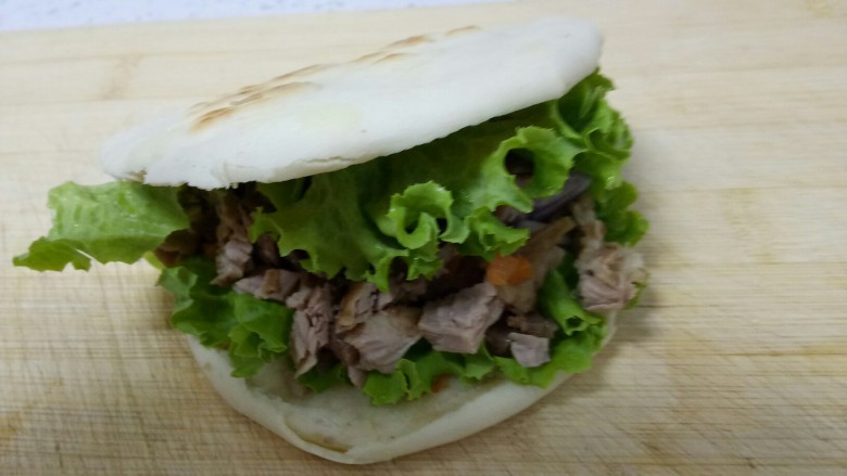 两种口味的夹馍,取出一个饼,用刀从中间切开但底部不要切段,夹上一片生菜和剁碎的🐷瘦肉、胡萝卜粒、洋葱粒。