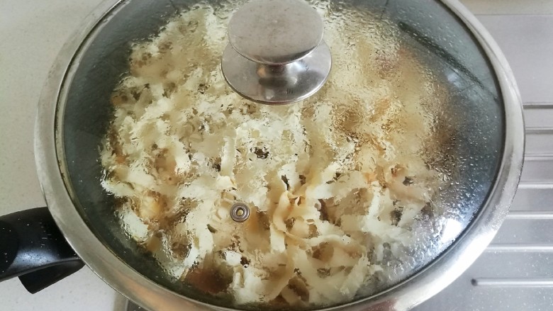 豆角番茄焖面,盖上锅盖,开始焖煮,汤汁淋入的多少最后决定面条的软硬程度。