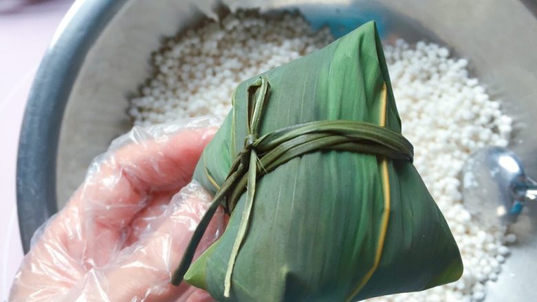 蜜枣西米粽子,用绑粽绳在粽腰处扎紧打结,一个紧实漂亮的粽子就包好啦。