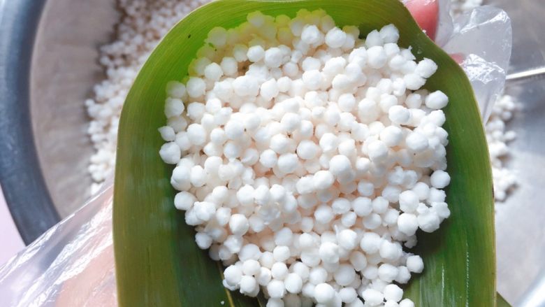 蜜枣西米粽子,再加入2/3的西米,用勺子轻轻压实;