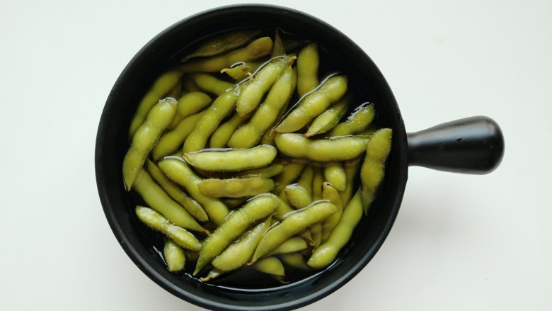 蒜泥毛豆,中火水烧开后,继续煮至15分钟(毛豆一定要煮熟,煮熟后即可关火),锅内浸泡20分钟。开始制作蒜泥。