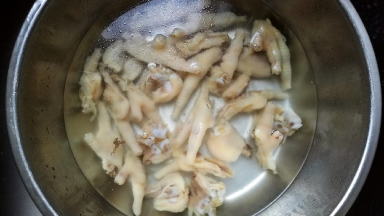 柠香泡椒凤爪,煮熟的鸡爪捞出后过一遍凉开水,洗掉浮沬。