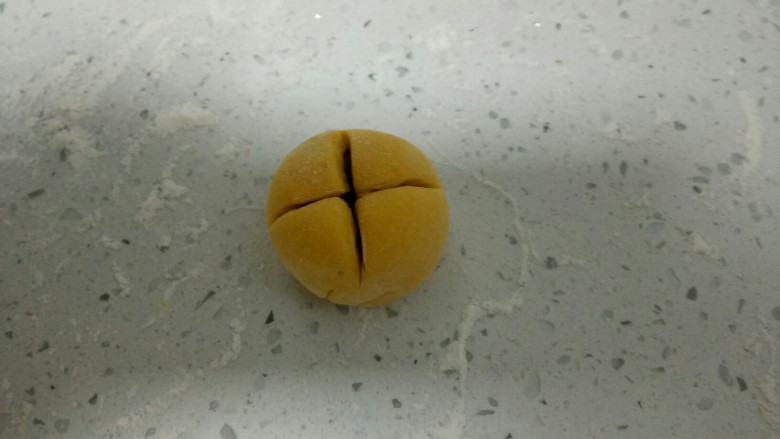 南瓜花样小馒头,收口后,光滑的一面朝上,用刀在中间分别垂直交叉切2刀。