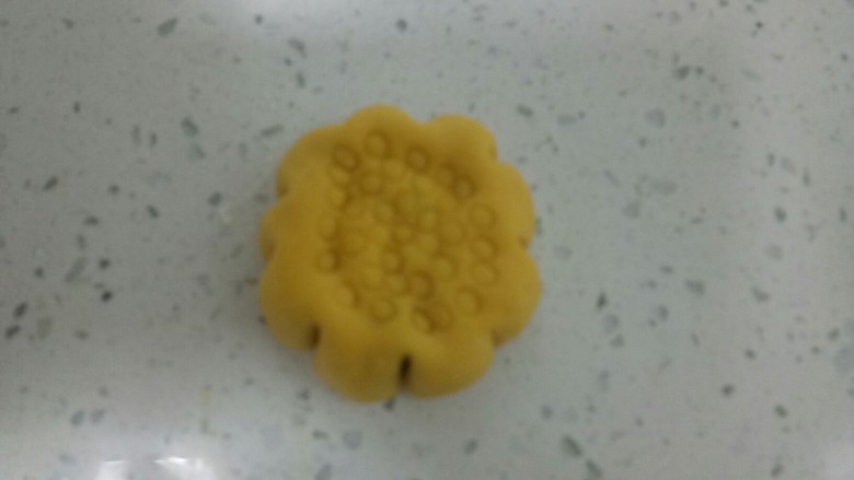 南瓜花样小馒头,收口后,光滑的一面朝上,用手压扁,两边用刮刀均匀往里推,再用吸管在上面按出圆圈。