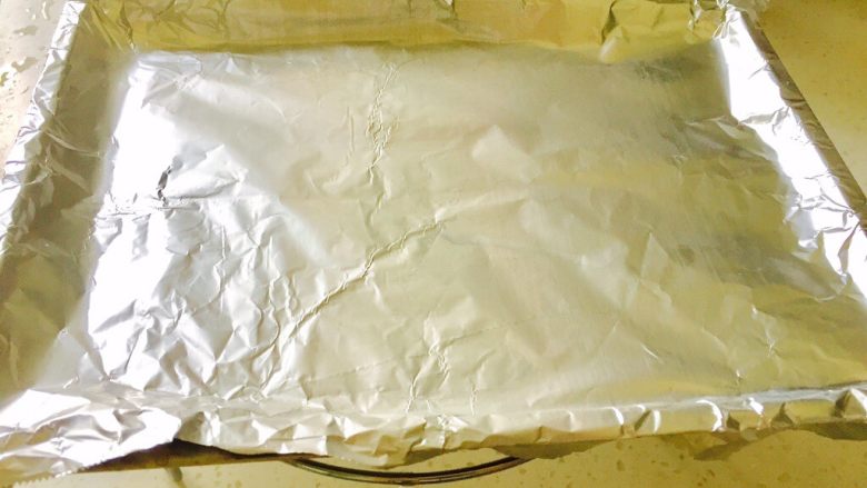 椒香盐封海鲈鱼,把烤盘铺上一层锡纸(准备烤之前把腌制好的鱼放冰箱冷藏半小时)
