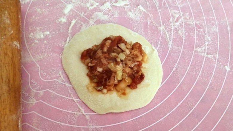 鲜嫩多汁~大葱肉包,擀成是四面薄,中间厚的片,然后再放上馅料
