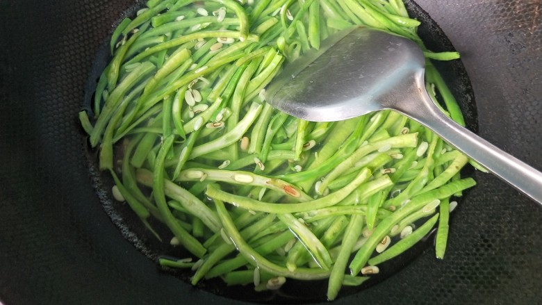 辣炒豆角,放一勺盐,放入豆角,焯水两分钟,捞出后过凉水。