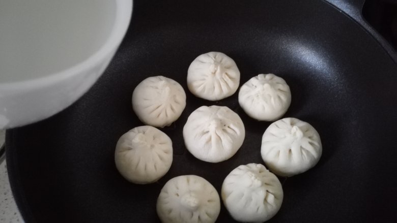 水煎包,倒入适量水,水要没过包子底部三分之一